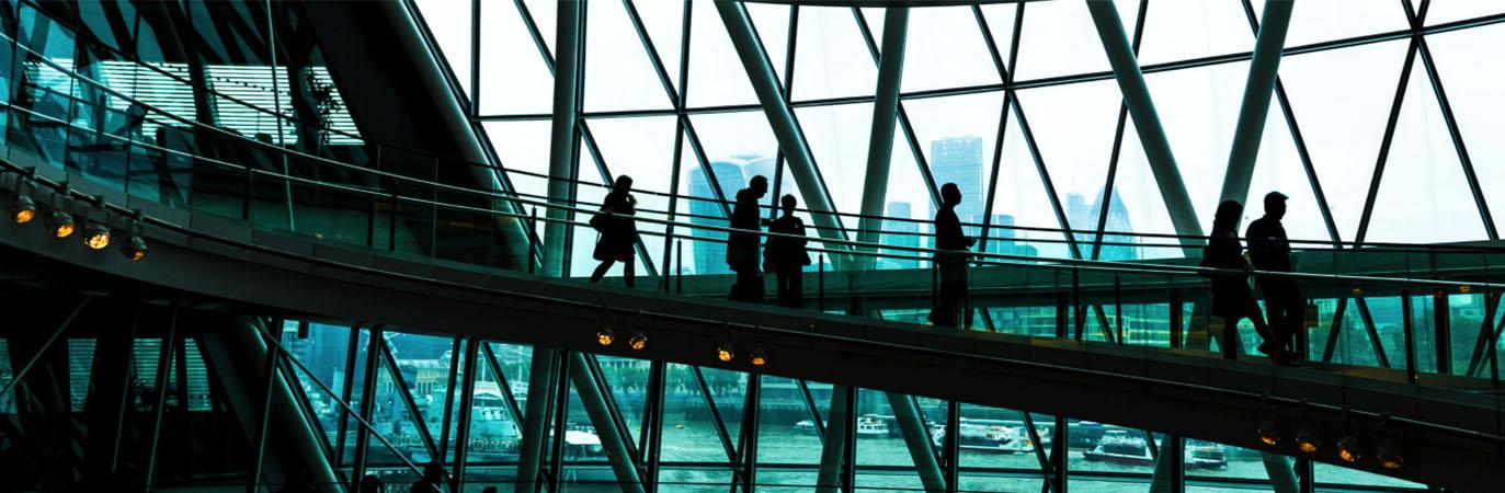 Interior of an office building with investment professionals walking Interior of an office building with investment professionals walking